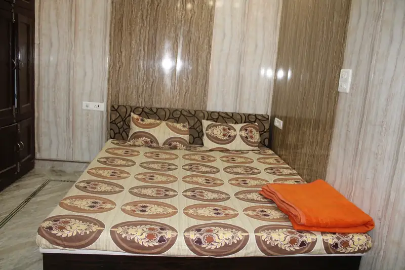 Simple double bed guest room with fresh towel at Sri Yoga Ashram Rishikesh